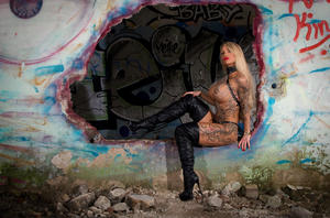 Tattooed blonde with large boobs models solo amid graffiti filled walls