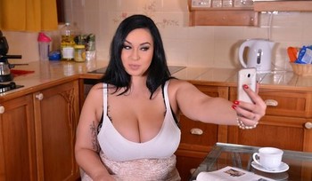 Thick brunette Anastasia Lux uncorking her massive all natural tits in kitchen